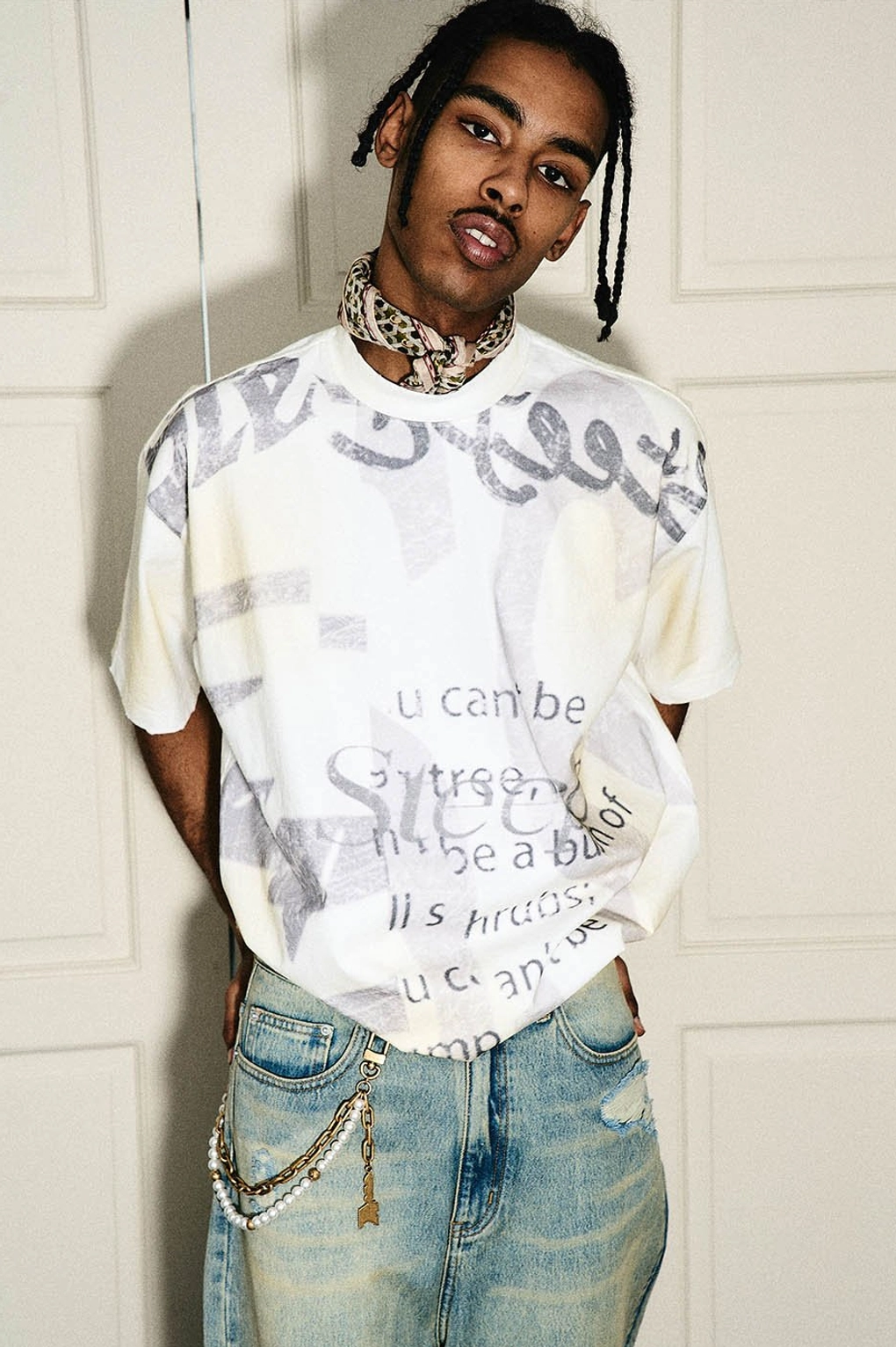 Model wearing a loose drop-shoulder graphic text T-shirt with vintage jeans and urban Korean street fashion styling