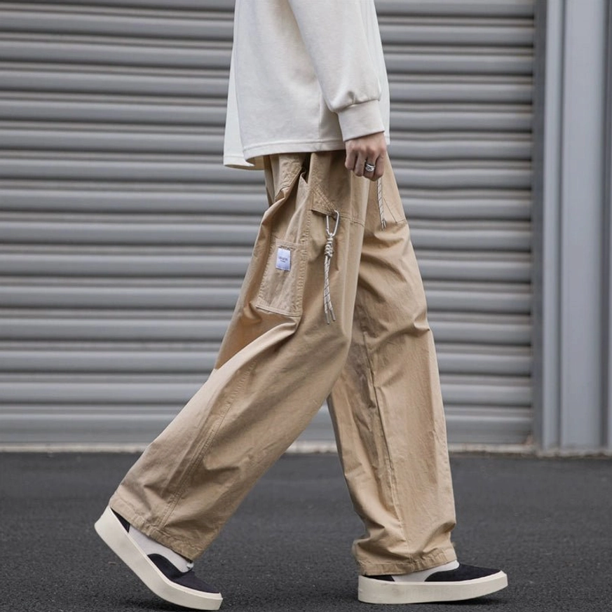 Khaki loose fit utility cargo pants with oversized drawstring side cargo pocket and wide straight leg silhouette