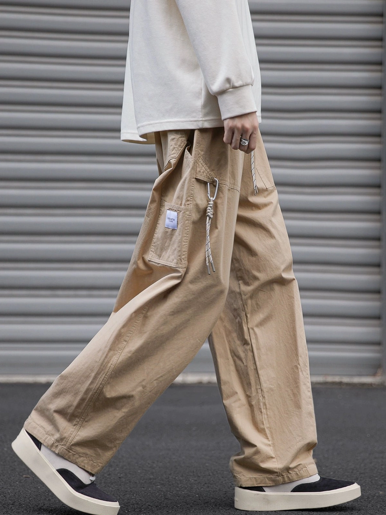 Khaki loose fit utility cargo pants with drawstring cargo pocket shown in a side walking Korean streetwear look