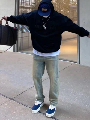 Male model wearing navy and off-white quilted platform sneakers with hoodie washed jeans and casual streetwear styling
