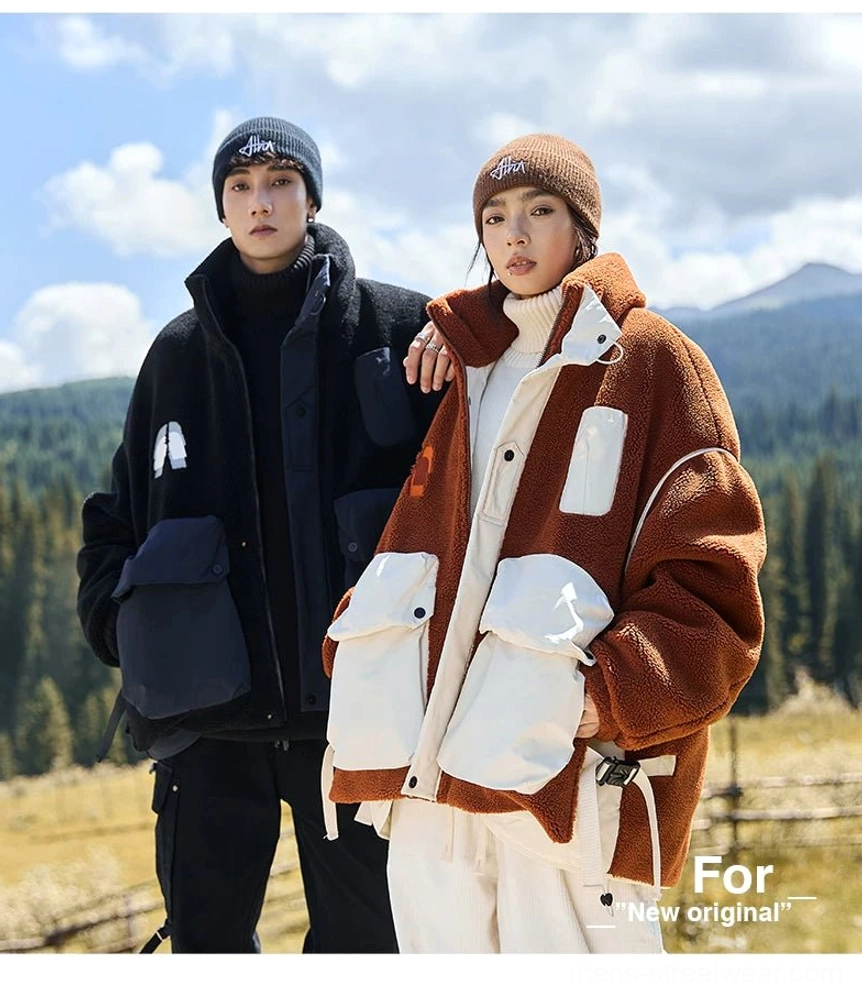 Couple wearing matching outdoor sherpa jackets in a mountain grassland setting with casual gorpcore styling