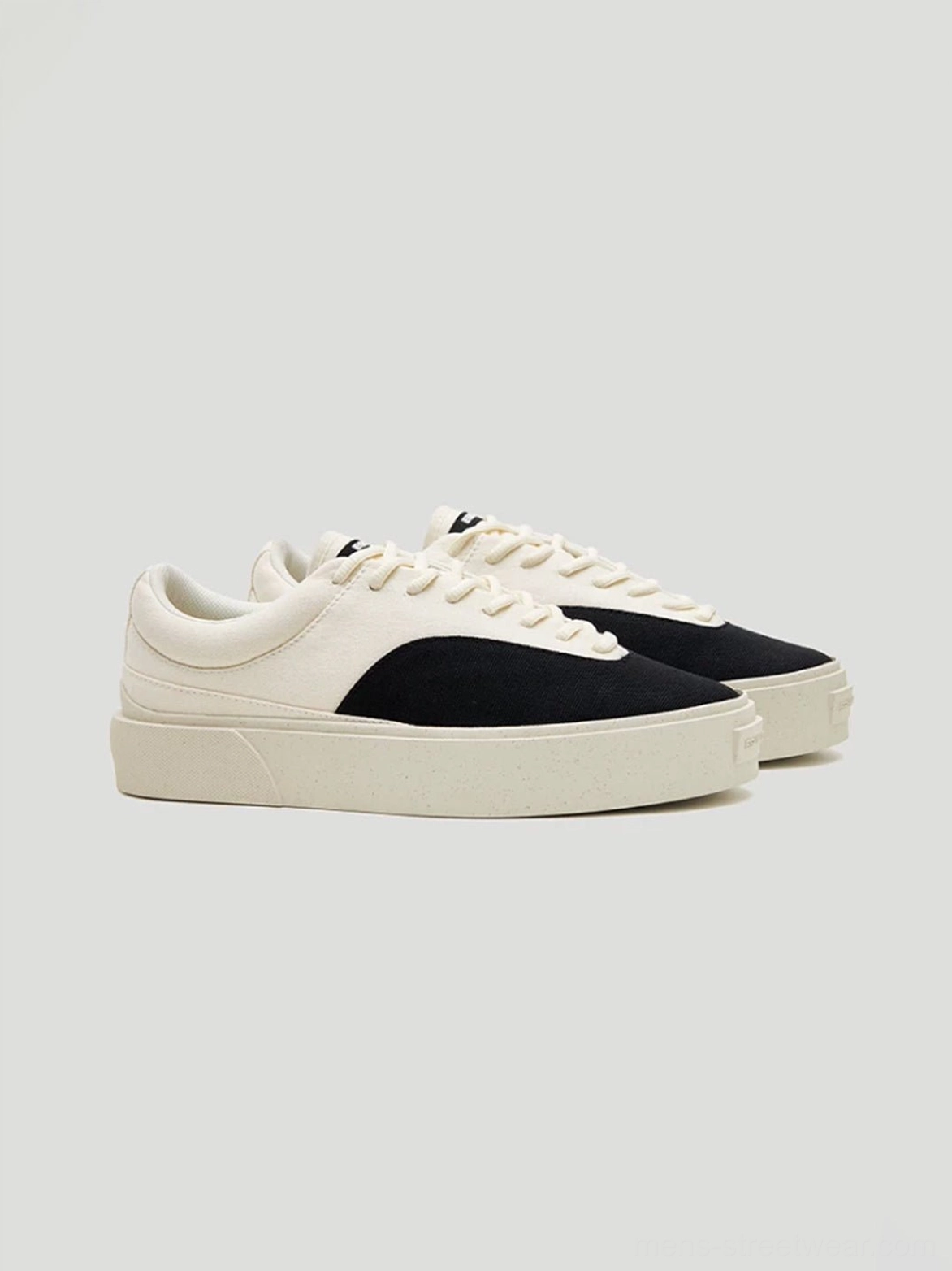 Pair of matching two-tone low-top canvas platform skate shoes with thick consistent rubber outsoles on a neutral background