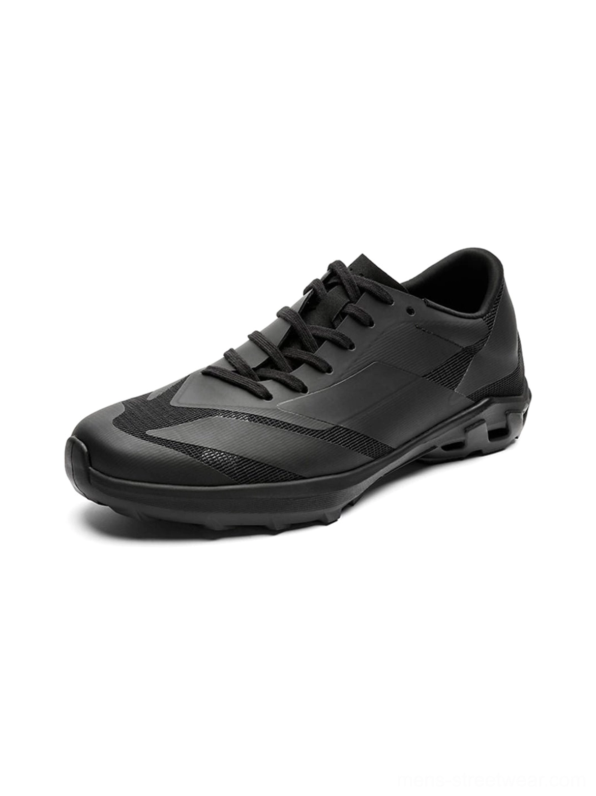 Three-quarter close-up of a matte black arch-support low-profile sneaker with geometric stitching, lace-up upper, and textured foam-rubber outsole
