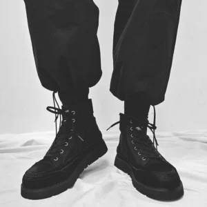 Front view of matte black high-top streetwear boots with metal eyelets, traditional laces, and thick chunky platform soles
