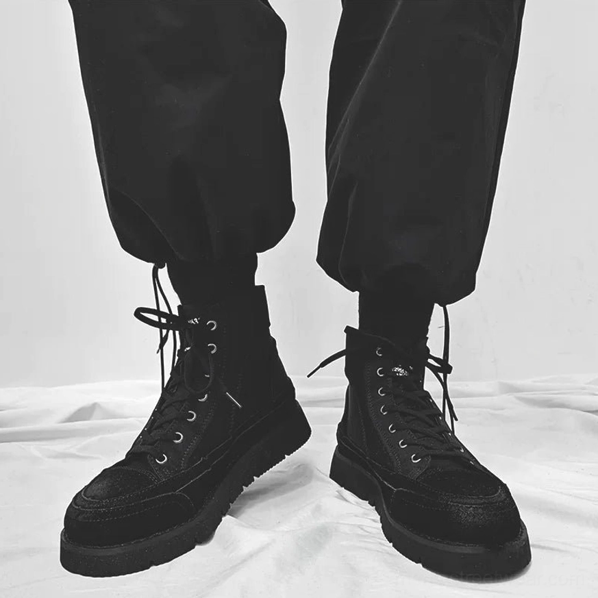 Front view of matte black high-top streetwear boots with metal eyelets, traditional laces, and thick chunky platform soles