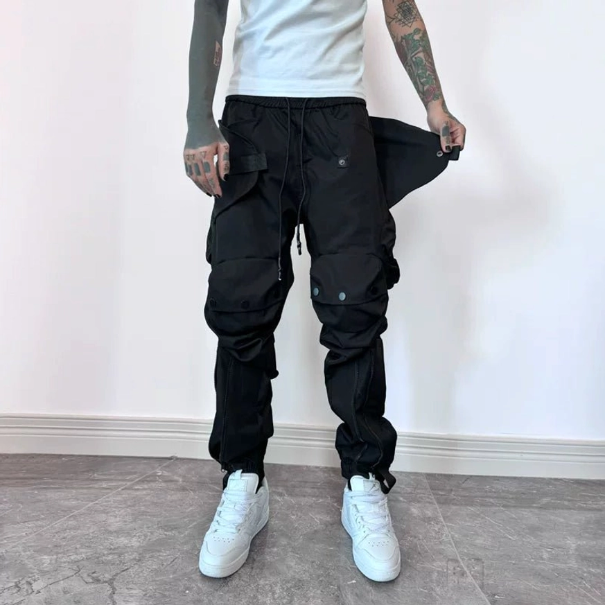 Matte black tactical cargo joggers close-up with revealable side pocket, multi-panel construction and drawstring cuffs