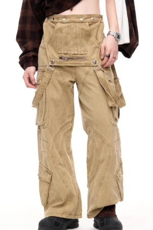 Men's apricot khaki detachable cargo pants shown from the front three-quarter view with a removable zipper pocket panel, wide-leg streetwear fit, and black leather boots