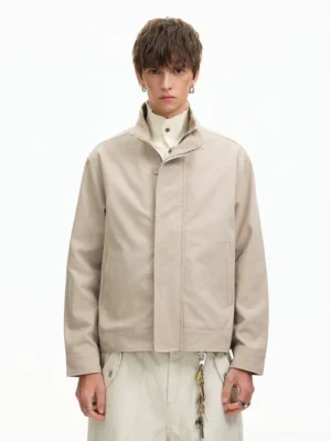 Men's apricot minimal stand collar Harrington jacket front view styled with turtleneck and cream cargo pants