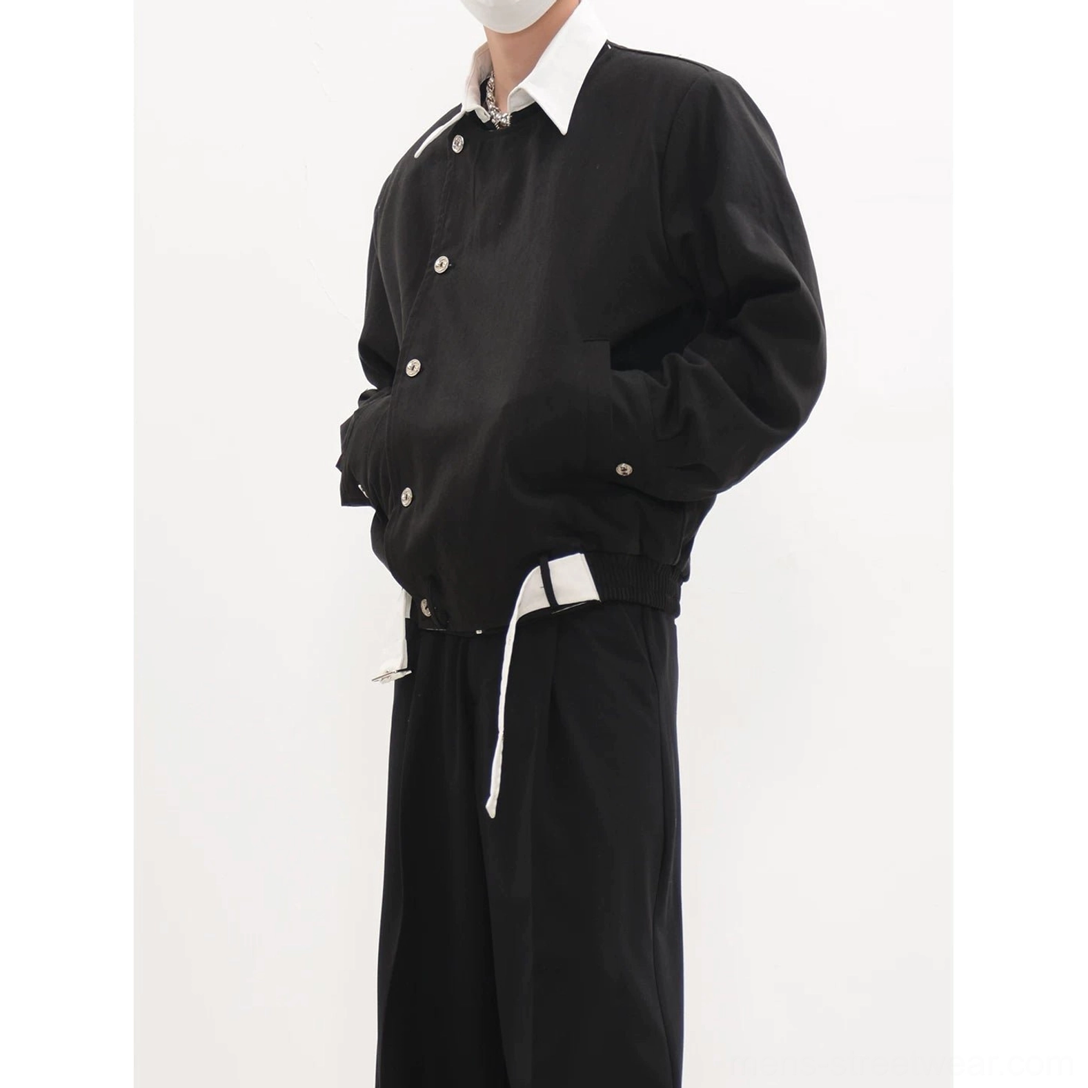 Black asymmetric button front blouson jacket showing collarless neckline diagonal closure and side hand pockets