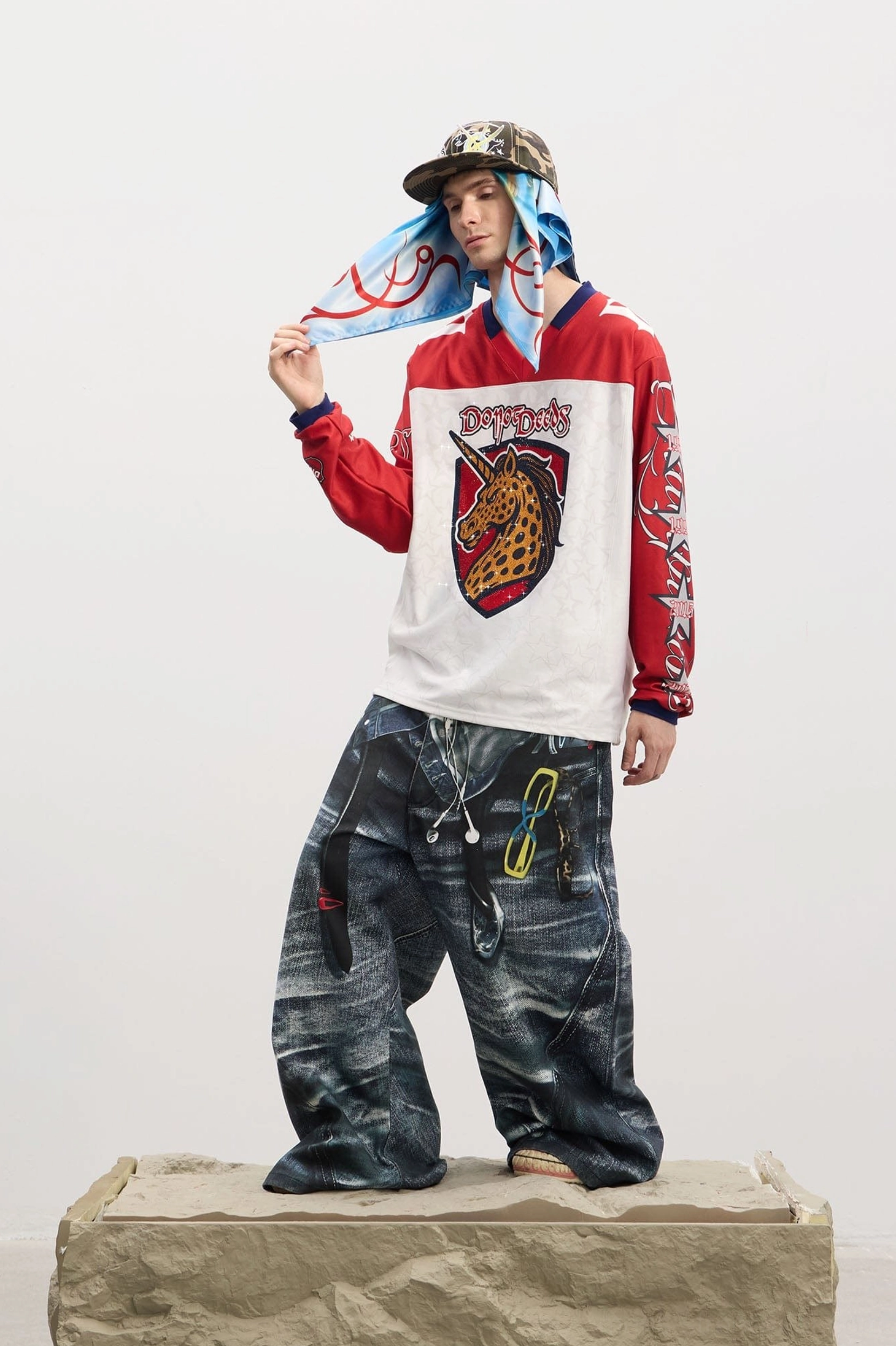 Front full-body view of men's baggy sagging-illusion denim jeans with faux pocket graphics, oversized wide legs, and Y2K streetwear styling