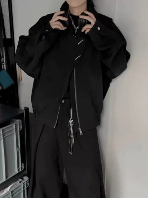 Close-up of men's black oversized bomber jacket with asymmetrical zipper collar hardware and relaxed streetwear sleeves