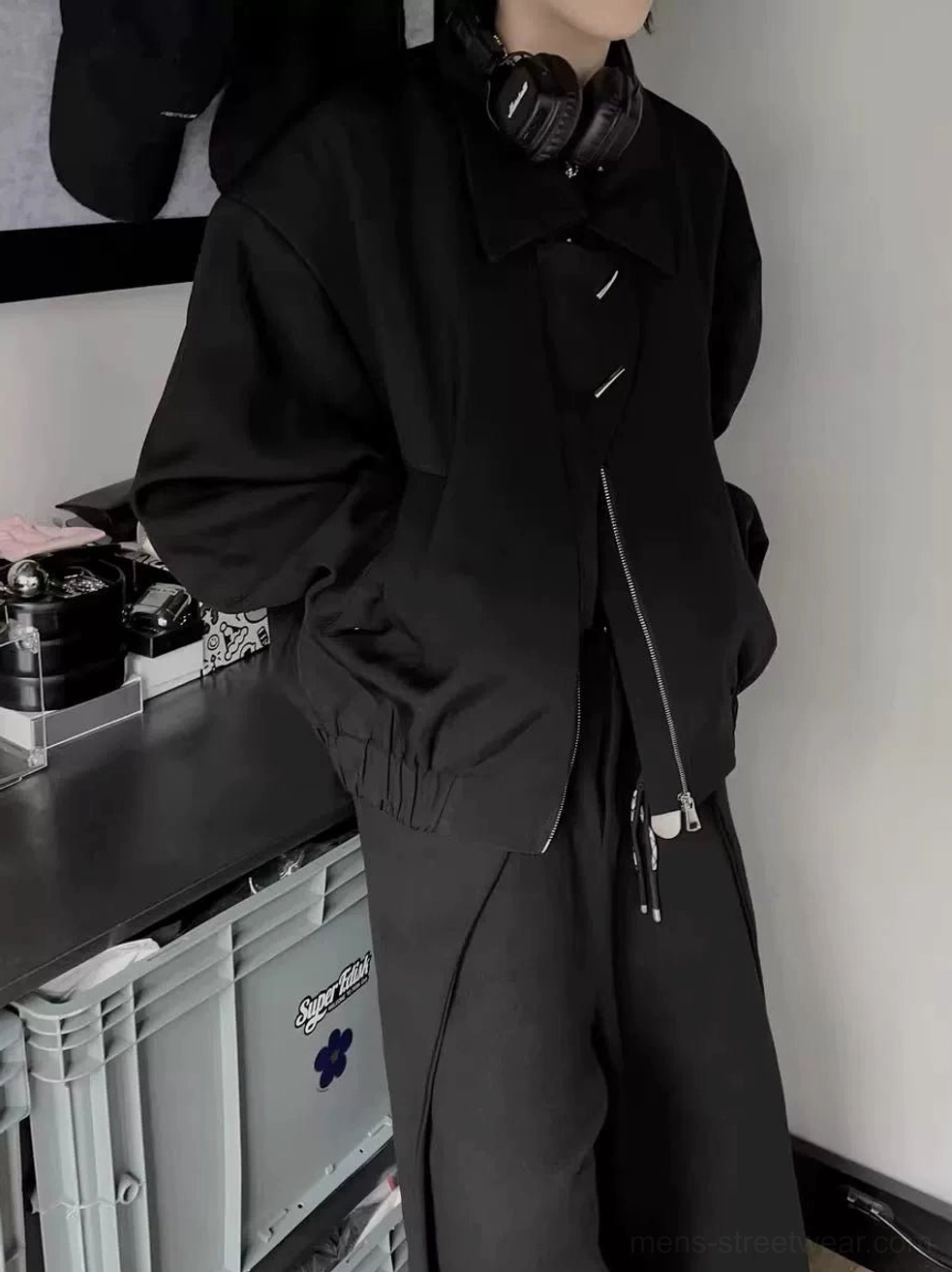 Men's black asymmetrical zip oversized bomber jacket in matte black shown in a three-quarter front view