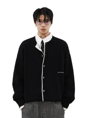 Men's black contrast piping knit cardigan with button front and embroidered chest detail layered over shirt and tie
