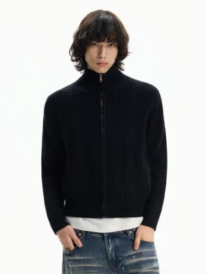 Men's black full-zip stand collar ribbed knit cardigan worn with white shirt and faded blue jeans front view