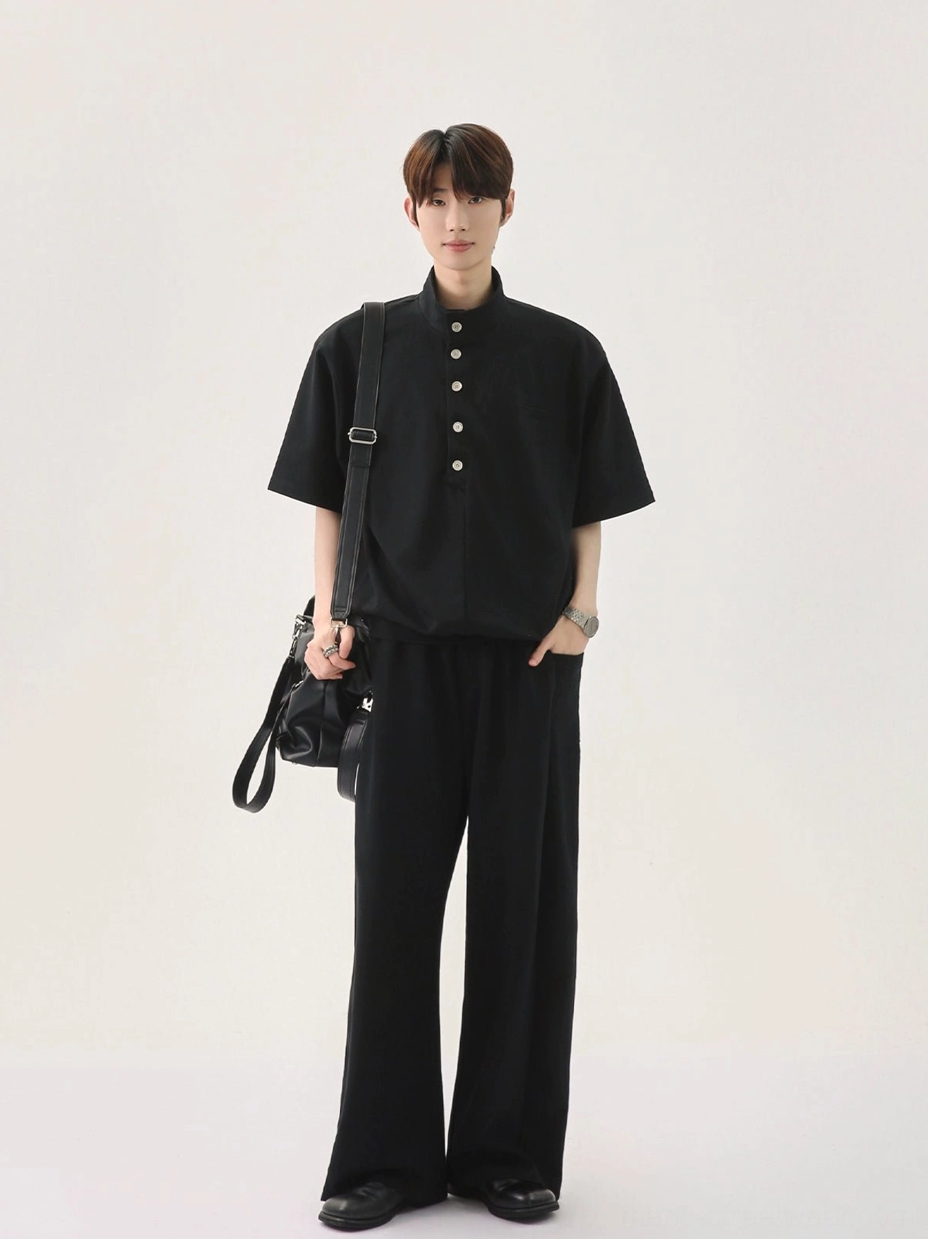 Side front view of men's black Korean streetwear polo shirt and wide-leg pants with chest pocket