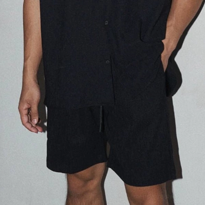 Men's black linen-look two-piece shirt and shorts set with minimalist monochrome streetwear aesthetic