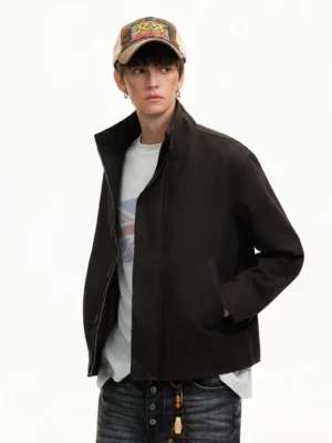 Men's black minimal stand collar Harrington streetwear jacket worn with dark denim in left three-quarter studio view