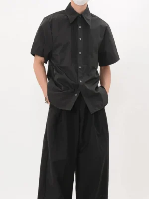 Men's black pleated tuxedo short sleeve shirt styled with black wide leg trousers in Seoul minimalist streetwear look