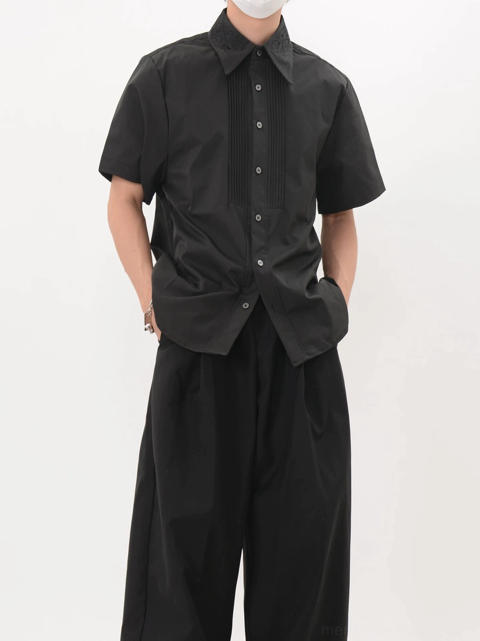 Men's black pleated tuxedo short sleeve shirt styled with black wide leg trousers in Seoul minimalist streetwear look