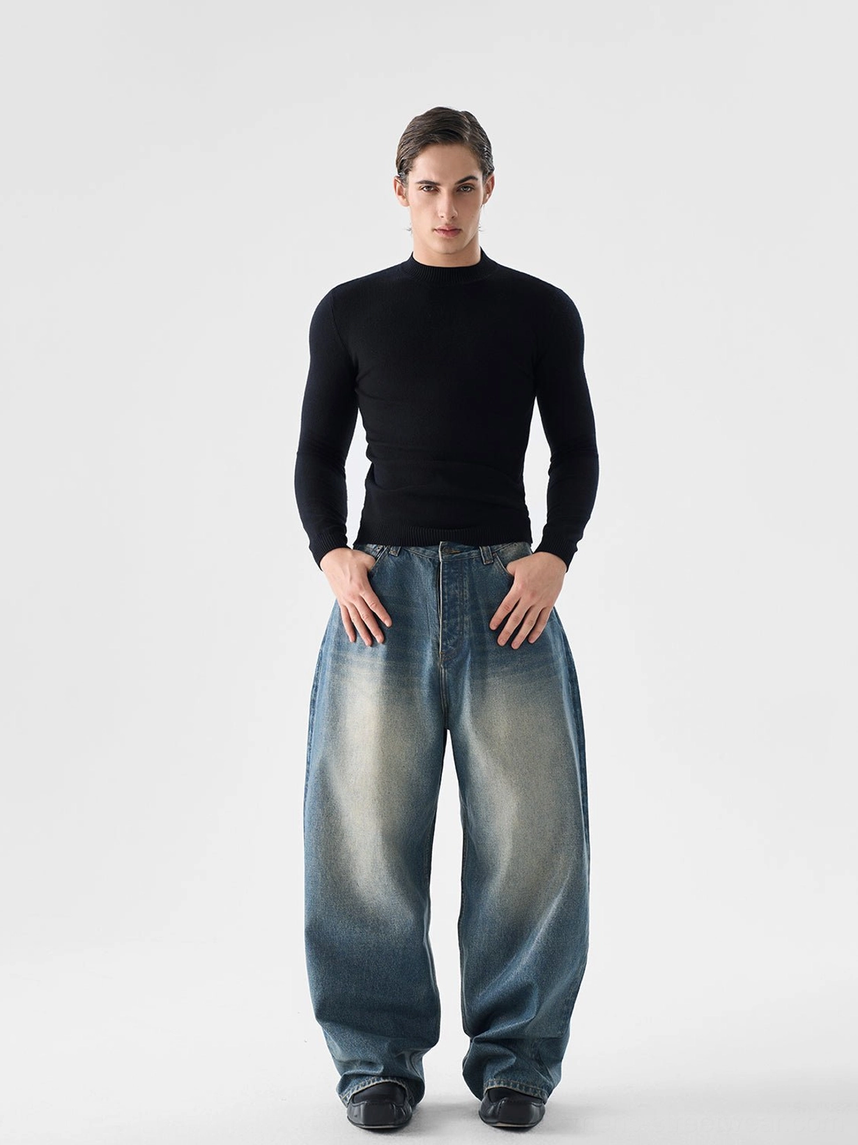 Men's black slim fit mock neck wool blend knit sweater front full body view styled with faded wide leg jeans