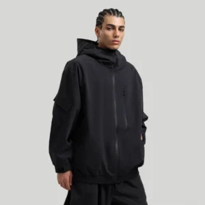 Men's black waterproof techwear ski shell jacket with concealed hood and utility zip pockets front three-quarter view