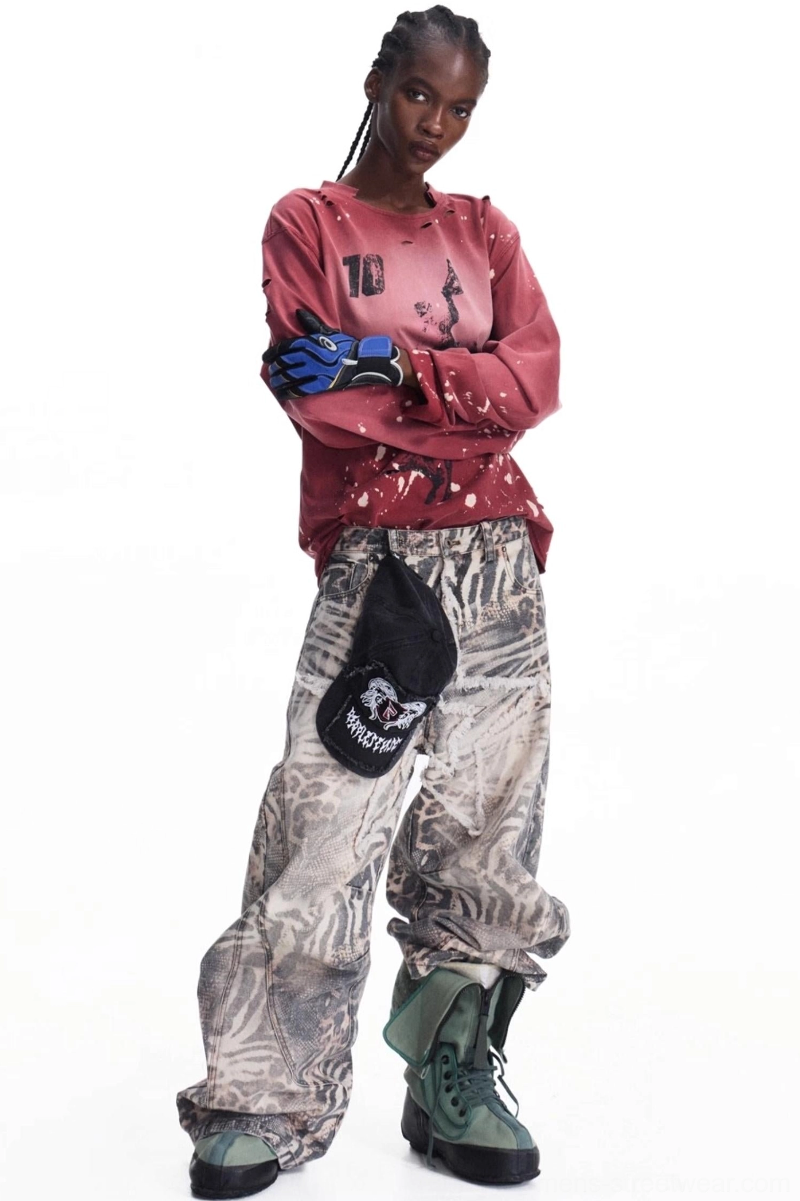 Men's burgundy distressed graphic long-sleeve T-shirt styled with camo wide-leg pants and combat boots, featuring vintage ink wash, front artwork, and splatter details