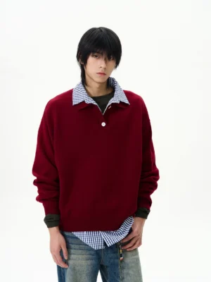 Men's burgundy faux layered knit polo sweater with plaid shirt hem styled with washed blue jeans front view