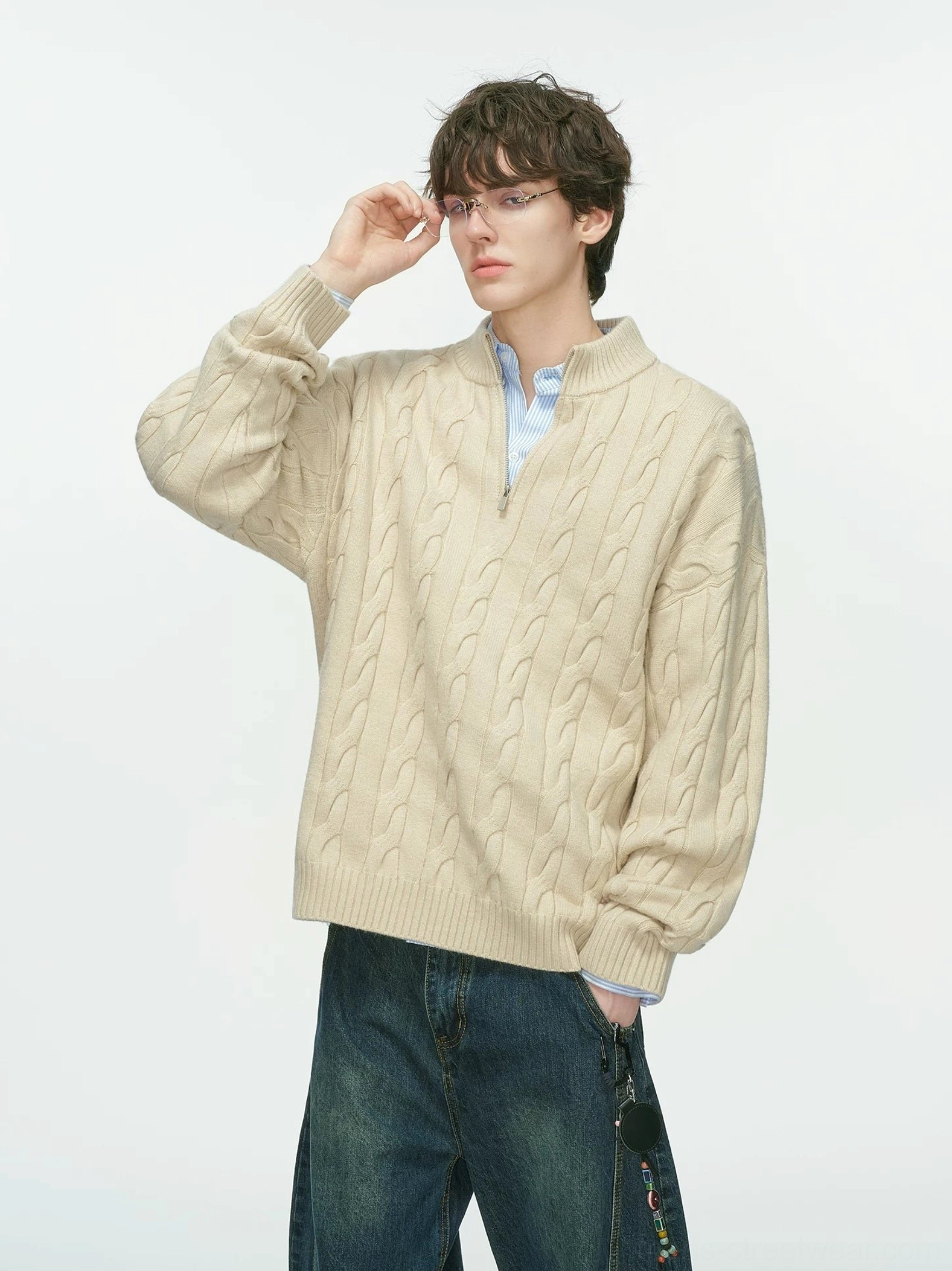 Three-quarter view of a beige cable knit half-zip sweater for men layered over a light blue shirt