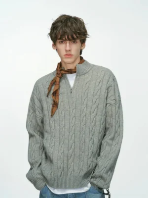 Front studio view of a grey cable knit half-zip sweater for men styled with a plaid scarf and blue jeans