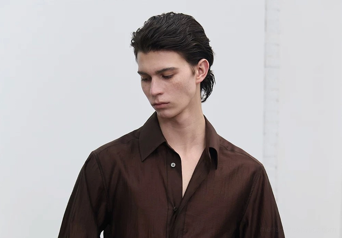 Close-up front view of men's dark brown fluid sheen shirt showing the pointed collar, button-front placket, semi-sheer texture, and open neckline