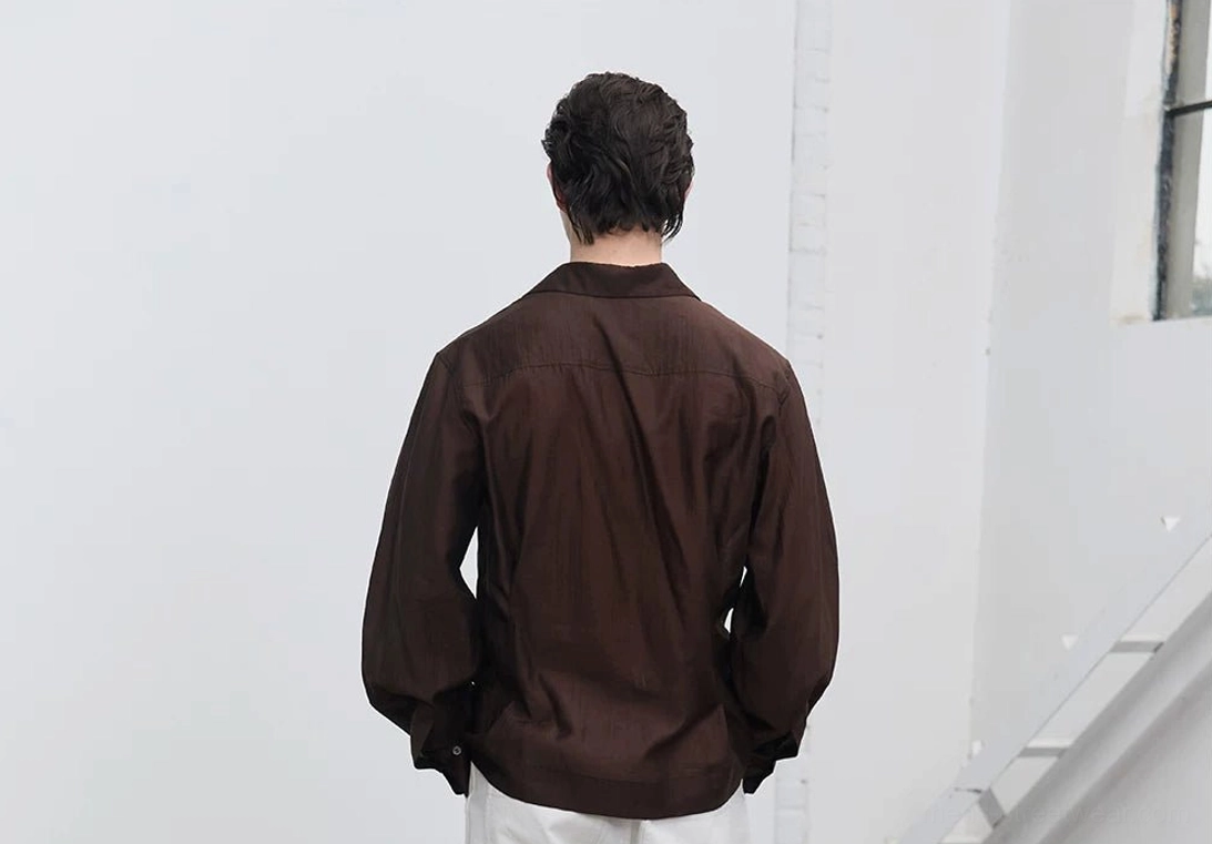 Back view of men's dark brown semi-sheer tailored long-sleeve shirt showing the flowing fit, shaped back, and buttoned cuffs