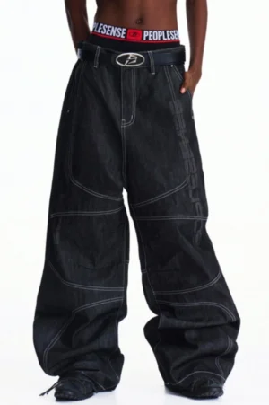 Front close-up of men's dark indigo wide-leg denim pants with oversized streetwear silhouette, contrast white topstitching, high waist, and belt styling