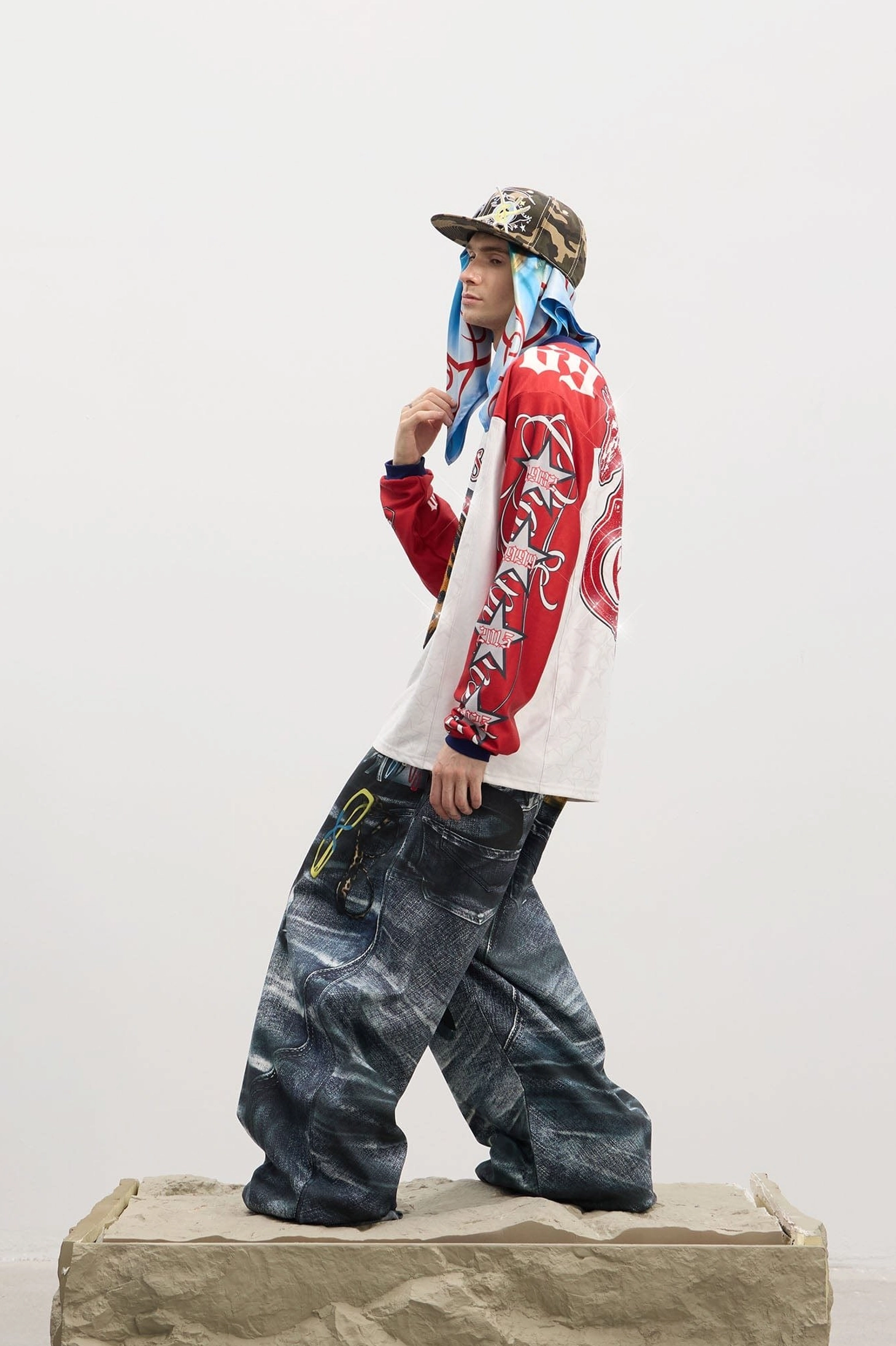 Side full-body view of men's dark wash wide-leg streetwear jeans styled with a graphic tee and bucket hat for a relaxed skater-inspired outfit