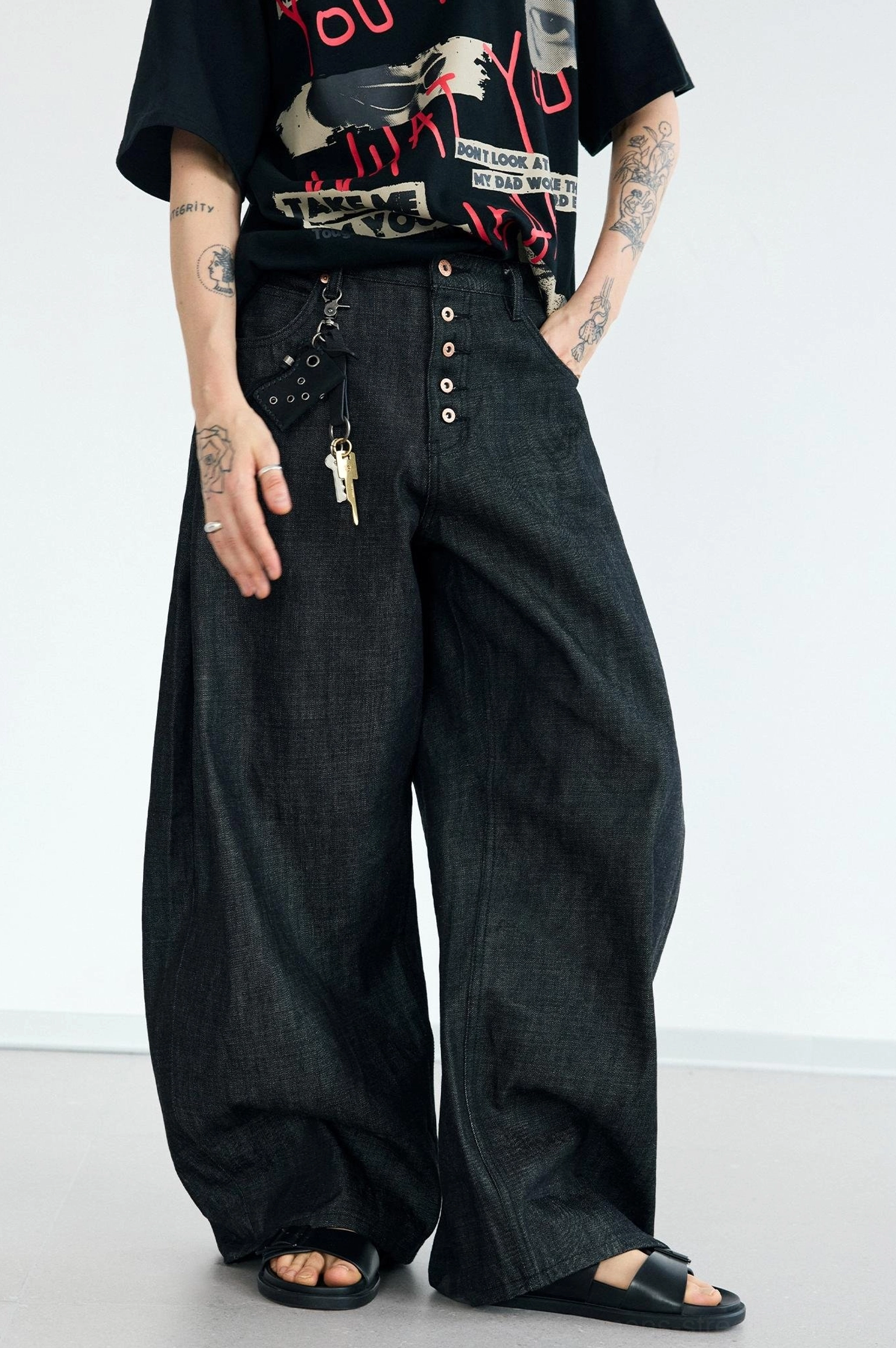 Relaxed full-body view of men's dark washed black oversized wide-leg jeans with a smooth denim texture and streetwear silhouette