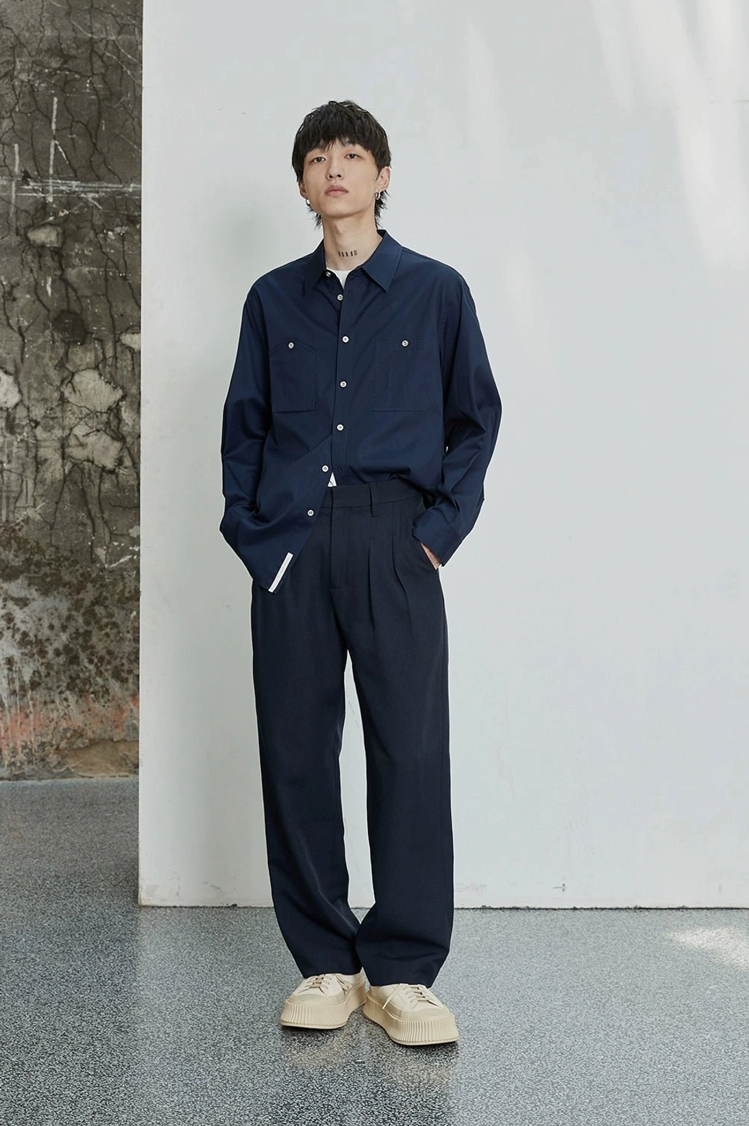 Mens double-pleated dress pants with hidden button closure and metal buckle back detail