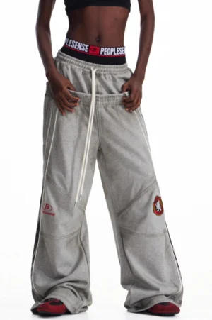 Front view of gray men's double-waisted oversized baggy streetwear sweatpants with wide legs, drawstring waist, and embroidered thigh accents