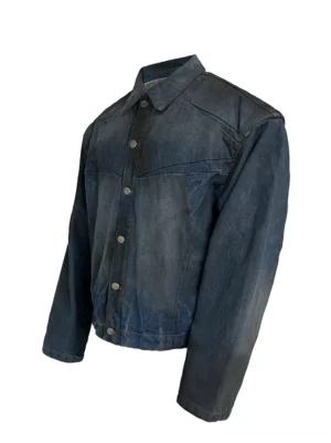 Front three-quarter product view of men's faded indigo panel denim trucker streetwear jacket with point collar and washed finish
