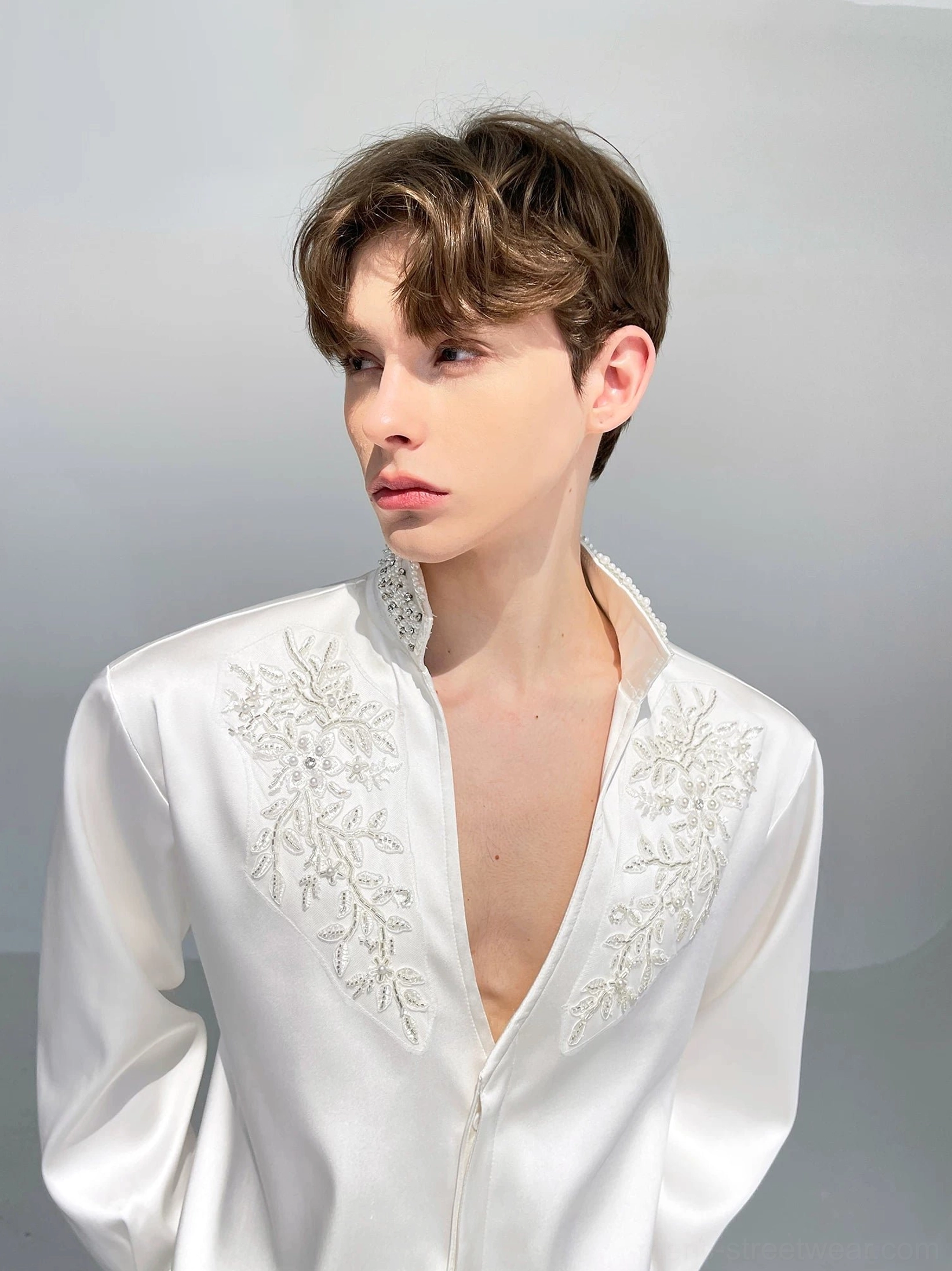Men's glossy white embroidered satin formal shirt featuring symmetrical floral beadwork and open V stand collar