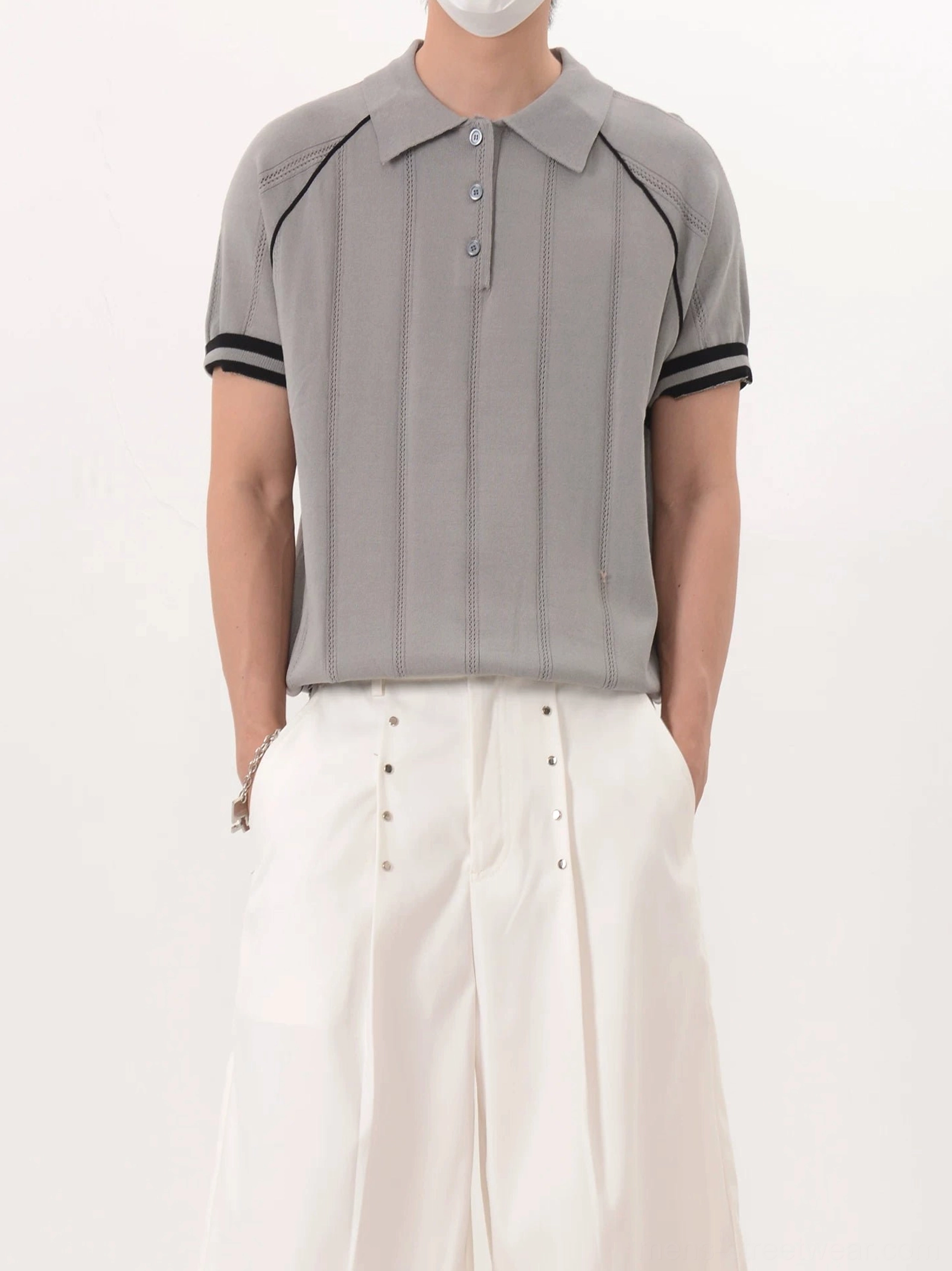 Men's gray contrast trim ribbed knit polo shirt side view styled with white wide-leg streetwear pants