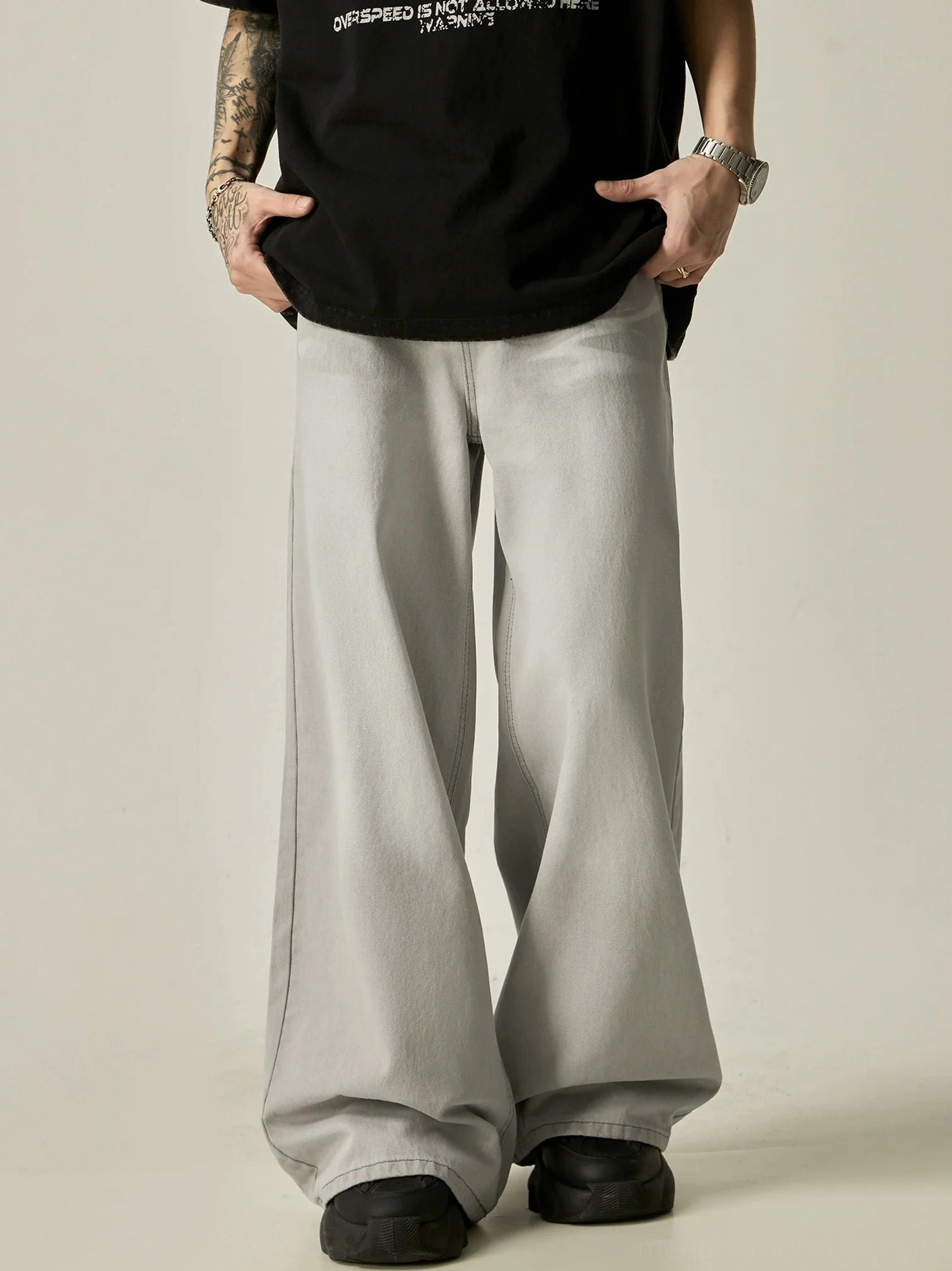 Men's light gray oversized wide-leg denim jeans styled with a black graphic oversized t-shirt in a streetwear outfit
