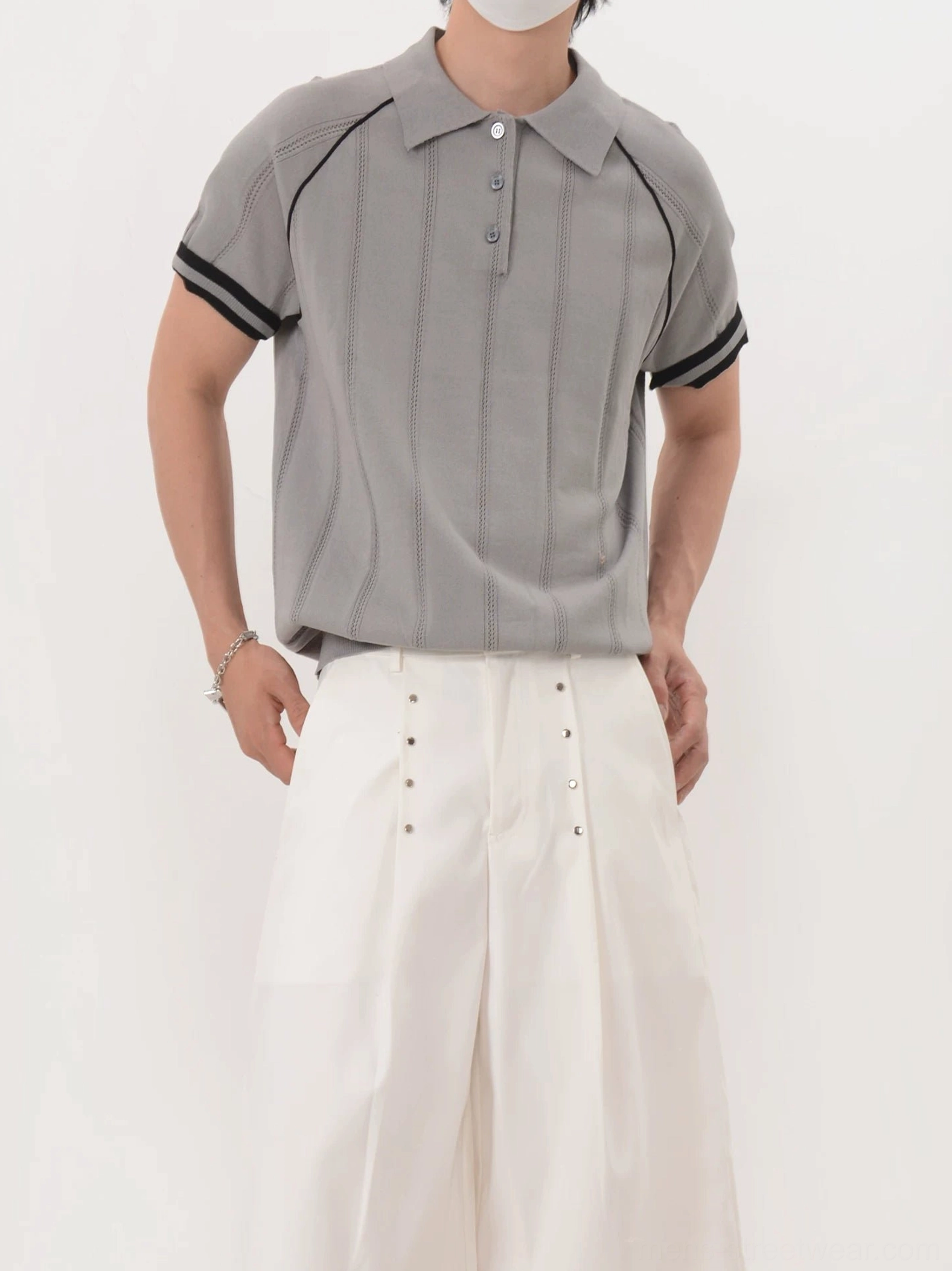 Men's gray short sleeve textured knit polo with black shoulder piping and striped cuffs front view