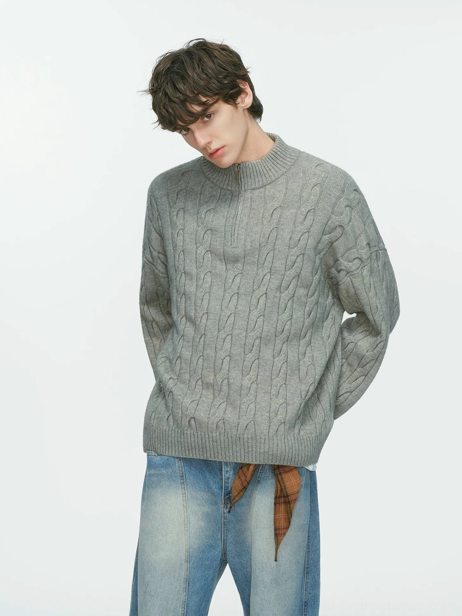 Back three-quarter studio view of a relaxed grey cable knit half-zip sweater styled with blue jeans