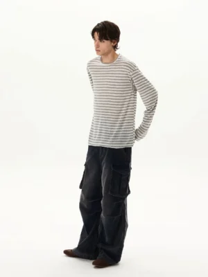 Men's grey and white striped slouch long sleeve tee styled with dark wide-leg cargo pants in a studio side view