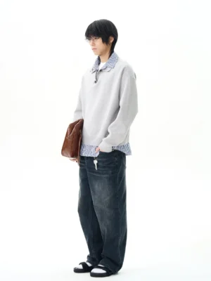 Men's heather gray faux layered knit polo sweater with checked shirt underlayer side view and wide leg jeans