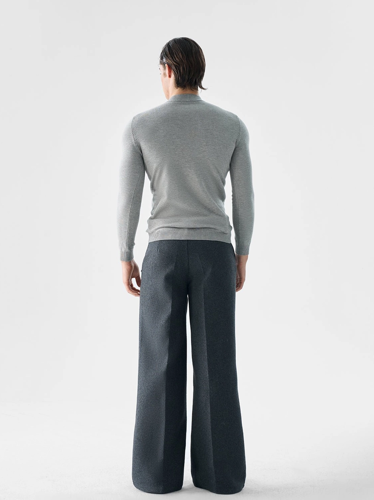 Men's heather gray slim fit mock neck wool blend sweater back full body view with dark gray wide leg trousers