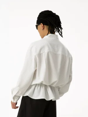 Back full-body view of men's Korean streetwear pinstripe tunic shirt showing relaxed back yoke, gathered drawstring waist, loose sleeves, and oversized hem