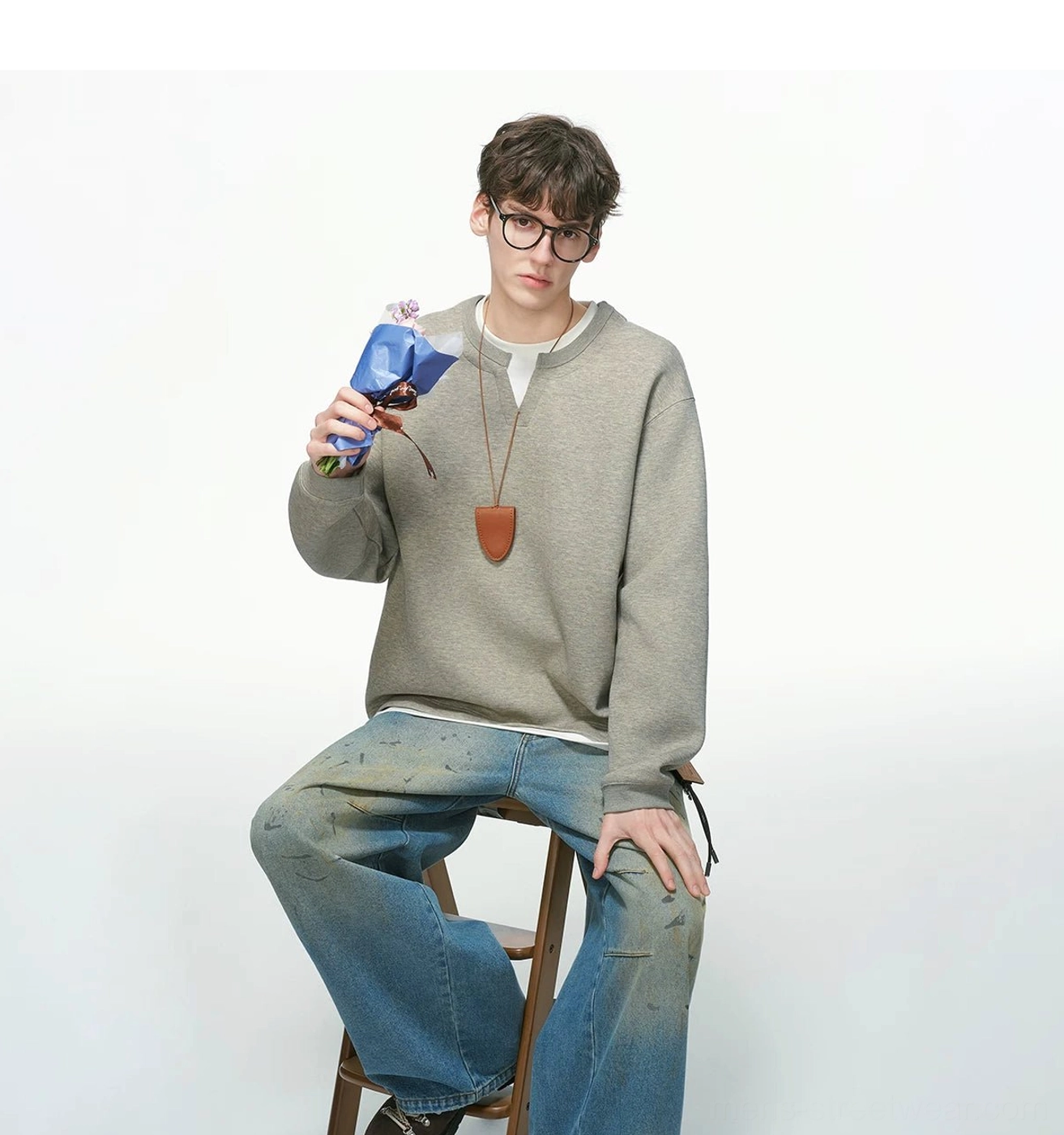 Men's layered crew neck sweatshirt detail view showing relaxed oversized Korean streetwear silhouette and contrasting faux undershirt trim
