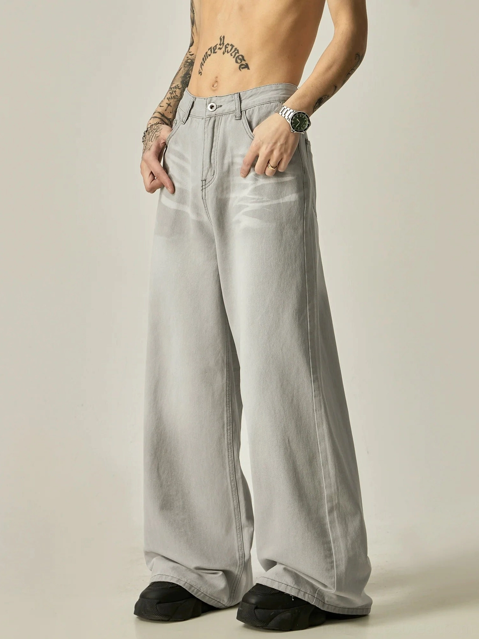 Three-quarter side view of light gray oversized vintage wash wide-leg denim jeans with classic waistband and pockets