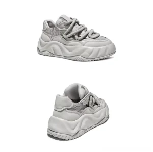 Rear lateral view of light grey men's chunky sneakers showing padded heel counter, layered leather construction, and wavy rubber platform outsole