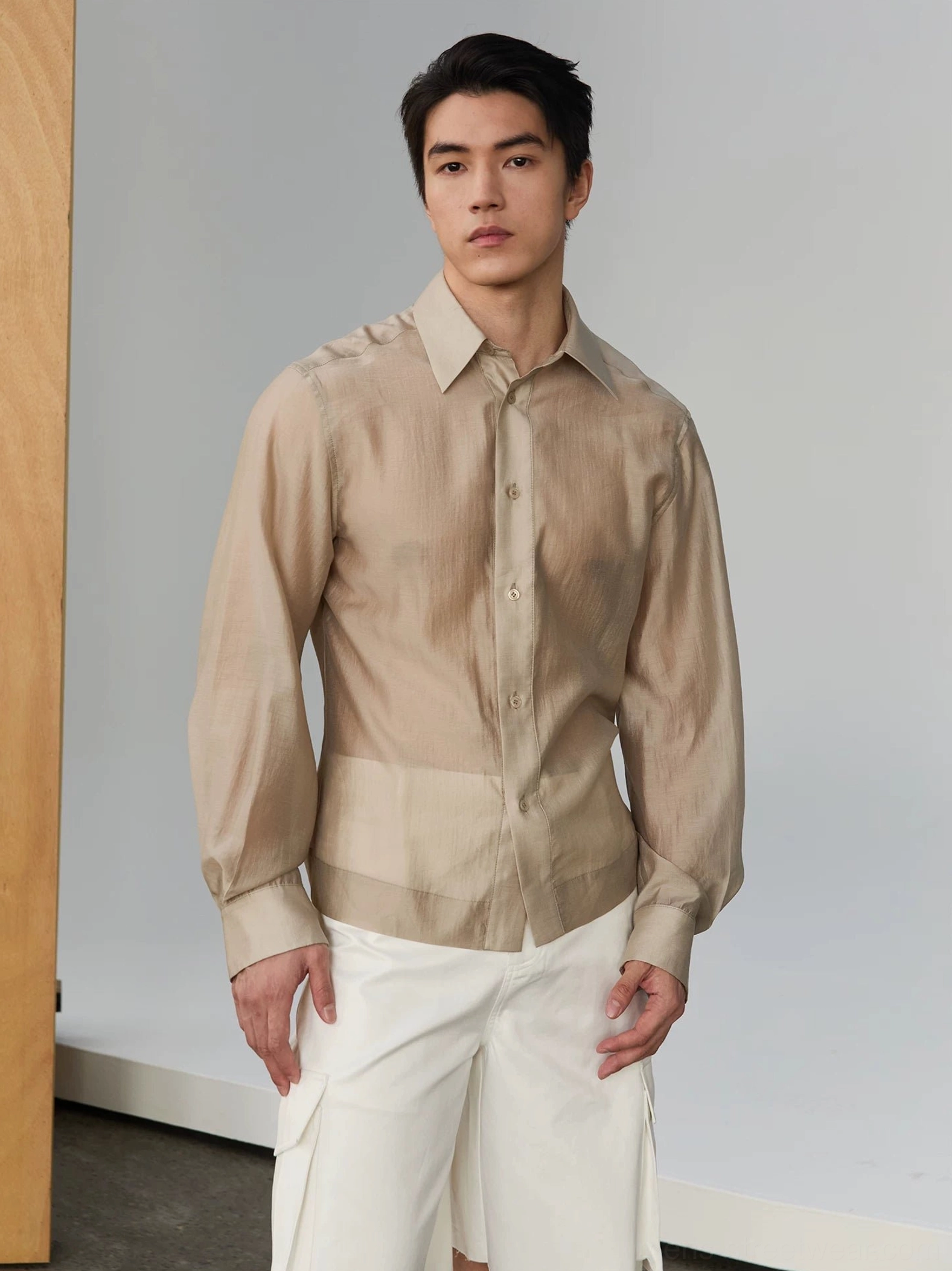 Men's light khaki semi-sheer silky tailored long-sleeve shirt styled with white cargo shorts in a modern Seoul streetwear look